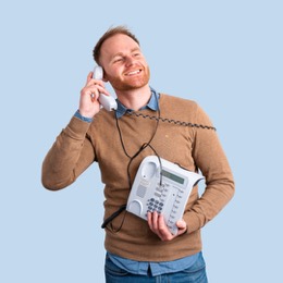 Mann lacht am Telefonhörer vor blauem Hintergrund