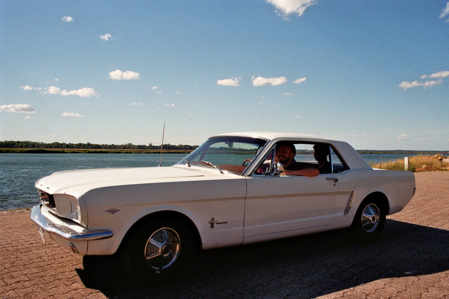 Weißer Ford Mustang am Wasser