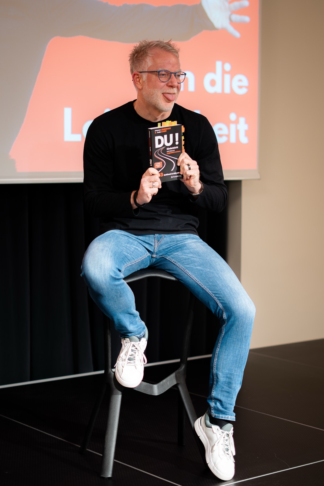 Redner zeigt sein Buch in die Kamera