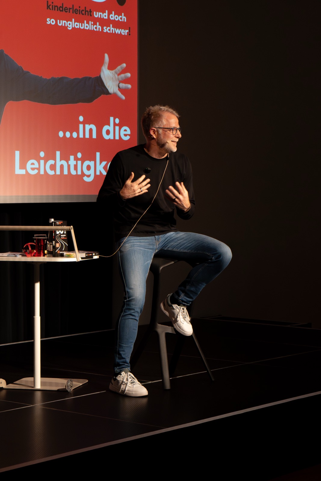 Redner erzählt gestikulierend auf der Bühne