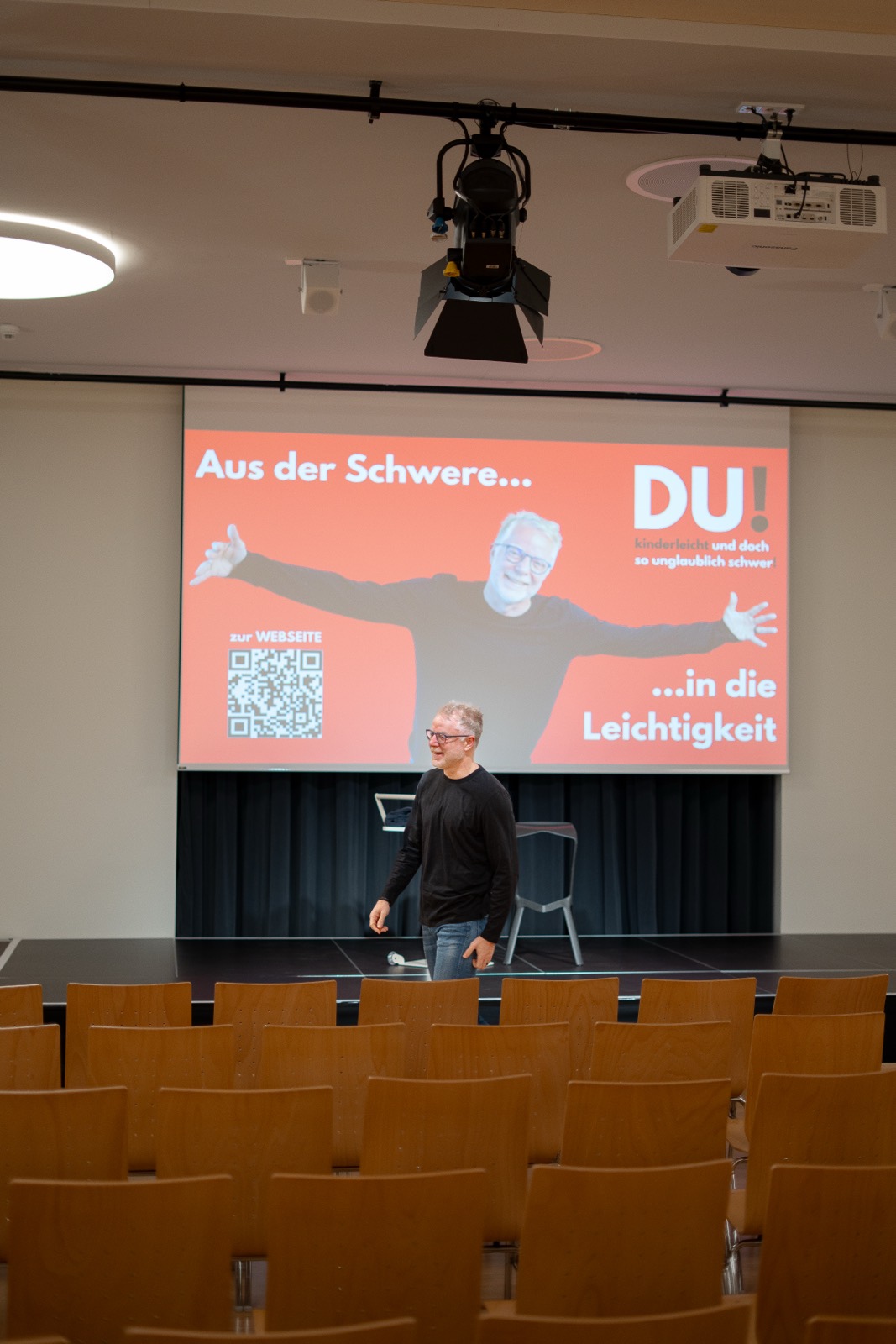 Redner auf der Bühne vor der DU!-Leinwand