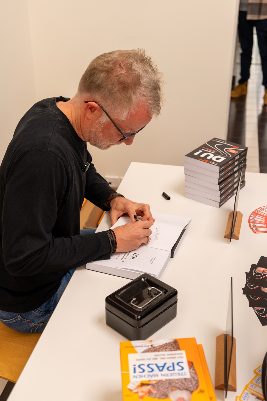 Autor signiert Bücher am Verkaufstisch