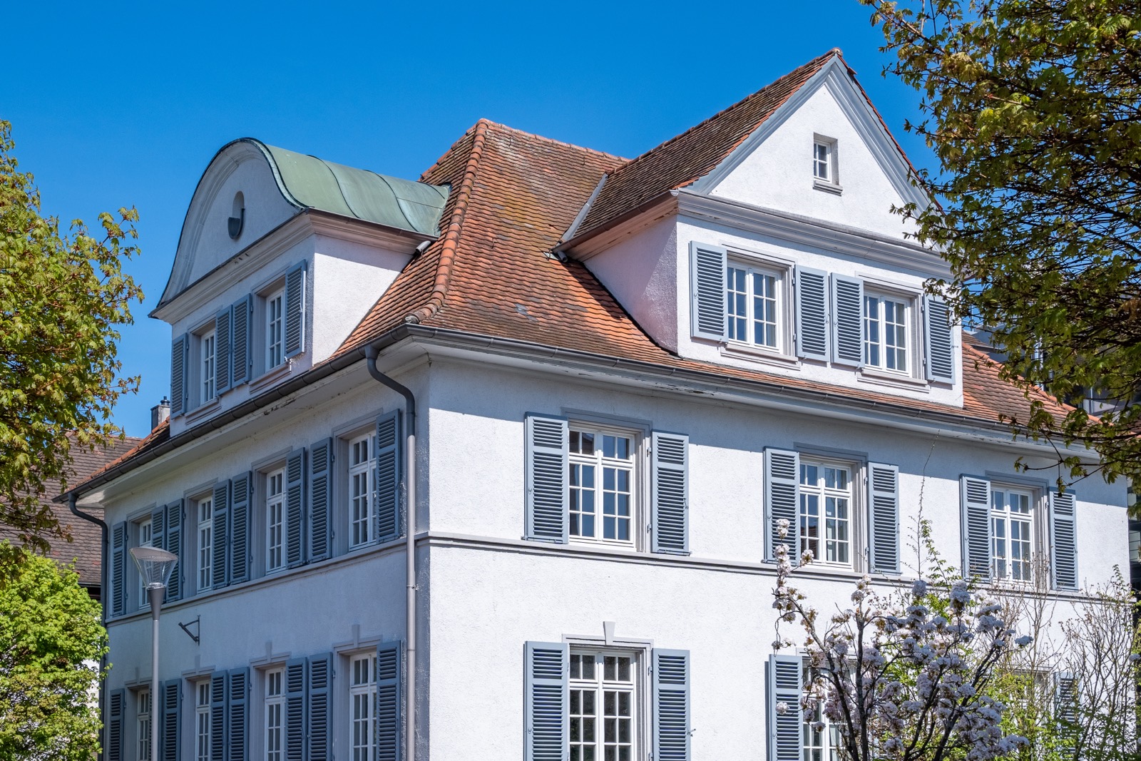 Historische Villa mit Klappläden und Mansarddach