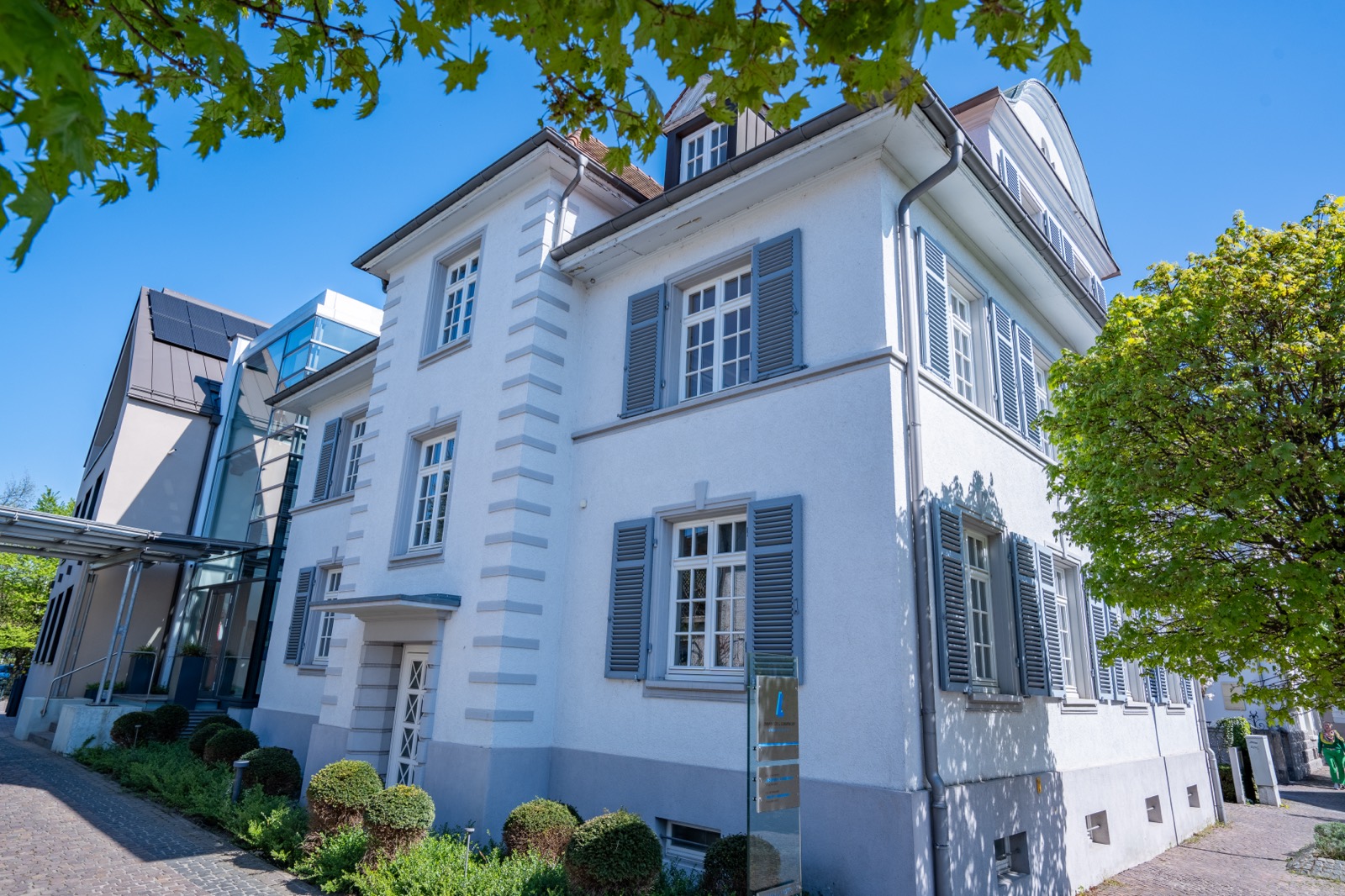 Villa mit gläsernem Verbindungsbau im Sonnenlicht