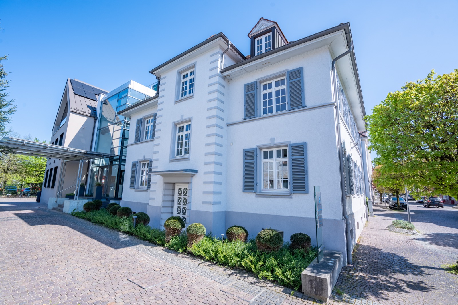 Villa und Neubau mit gepflastertem Hof