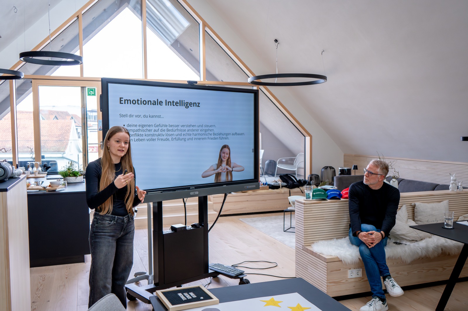 Teilnehmerin präsentiert vor dem Bildschirm „Emotionale Intelligenz“