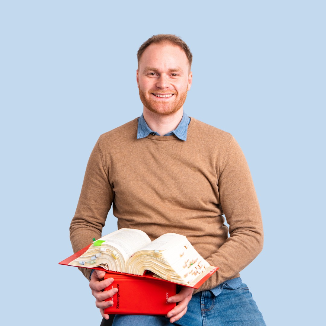 Mann mit einer Kiste voller Gesetzbücher