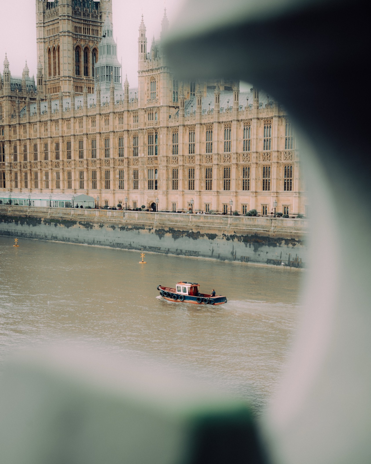 Houses of Parliament und Themse durch eine Lücke gesehen