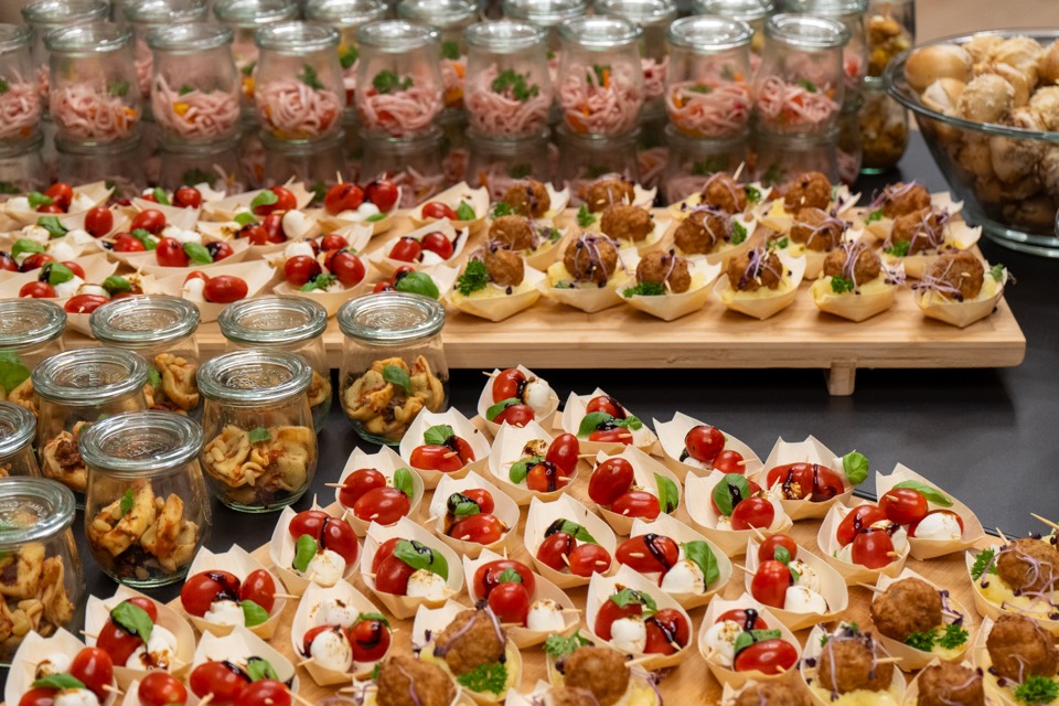 Buffet mit Tomate-Mozzarella-Häppchen und Gläsern