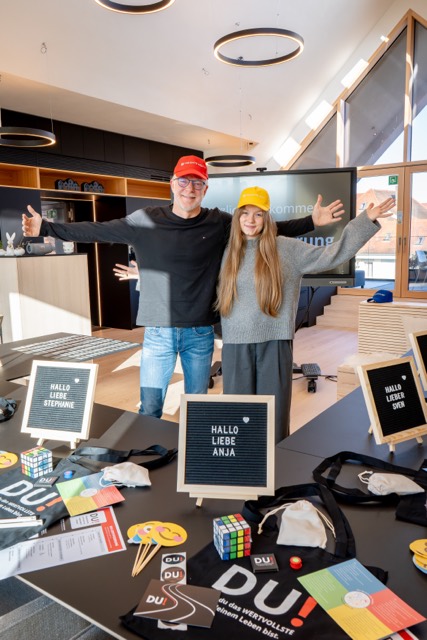 Zwei Trainer mit Caps hinter den gedeckten Plätzen
