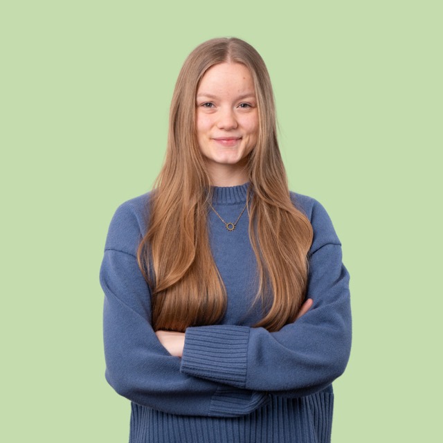Junge Frau im blauen Pullover mit verschränkten Armen