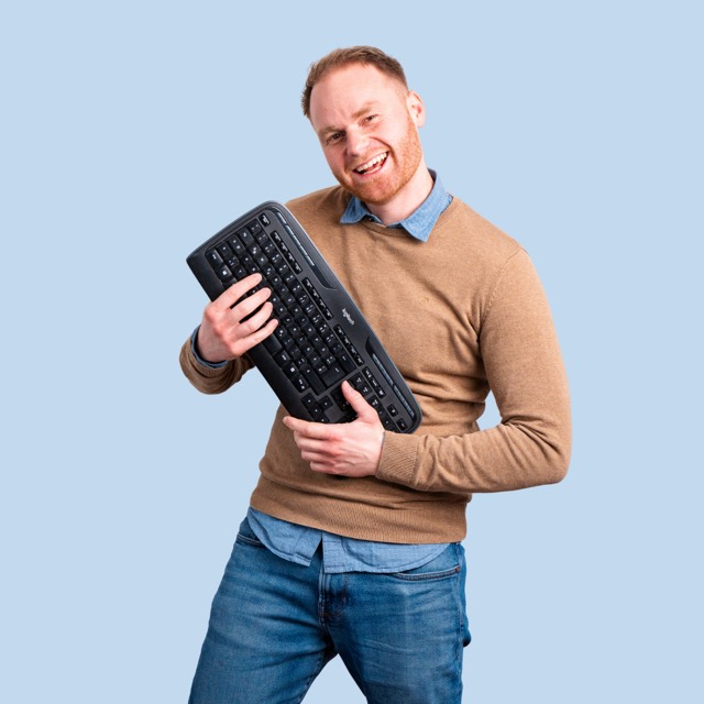 Mann spielt Luftgitarre mit einer Tastatur