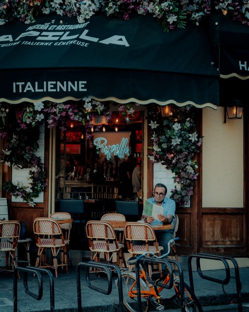 Italienisches Café mit Blumen über dem Eingang