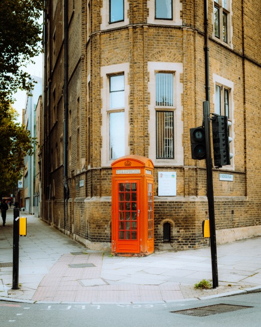 Rote Telefonzelle an einer Backsteinecke