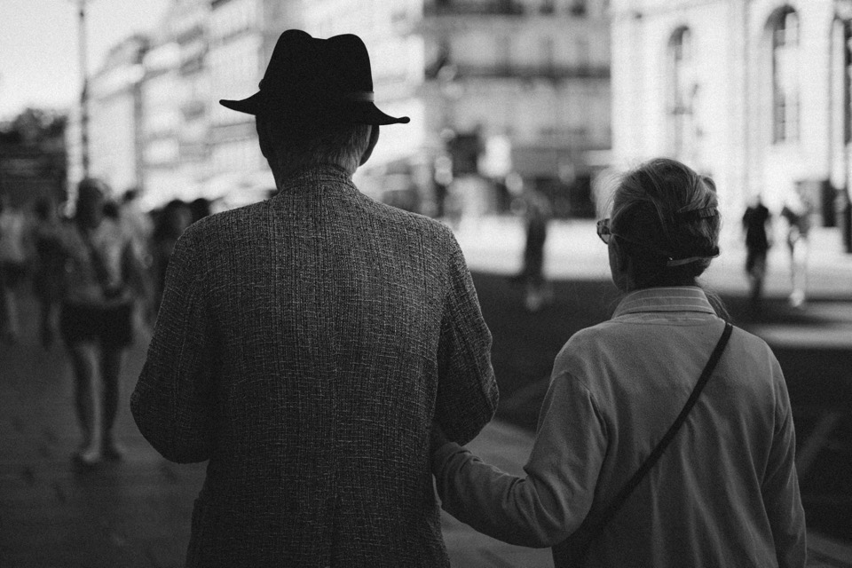 Mann mit Hut und Frau Arm in Arm, Schwarzweiß